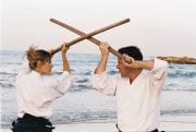 Miles Kessler and student with bokken on beach